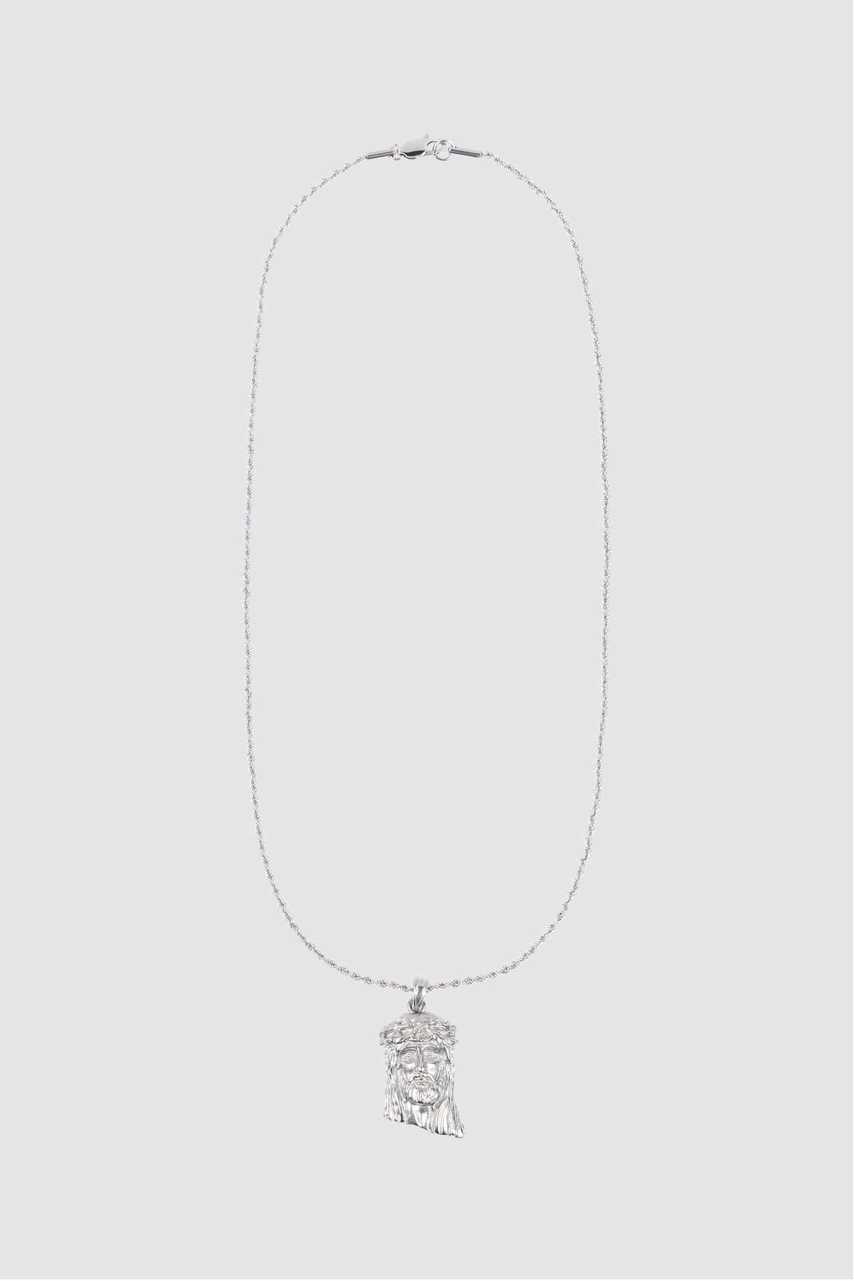 A delicate PESOCLO Jesus Piece silver rope chain necklace, featuring a finely detailed metallic Jesus pendant reminiscent of a feather or wing, shown against a plain light gray background.