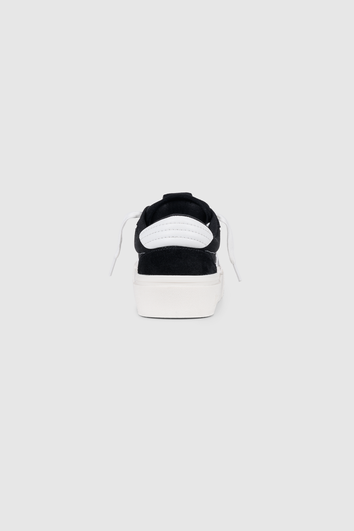 Back view of the PESOCLO Peso Skate sneaker in black, showcasing an artwork upper crafted from a canvas-suede mix, white laces, and a thick white sole, all centered on a plain light gray background.
