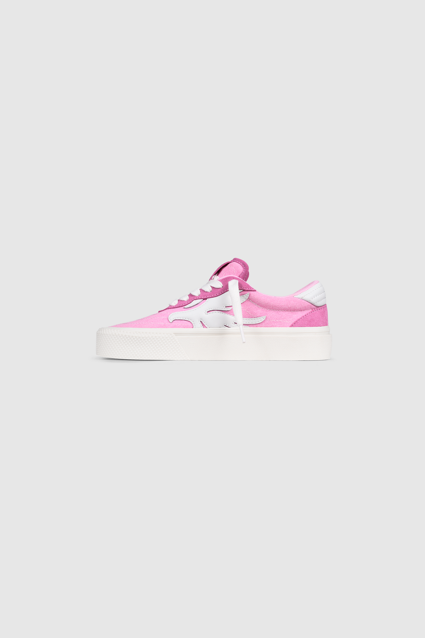 Introducing the PESOCLO Peso Skate: a pink and white low-top sneaker featuring white laces, a thick white sole with subtle artwork, and a minimalist design crafted from a canvas-suede mix—presented against a plain light gray background.
