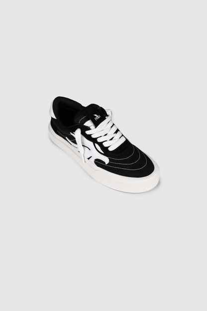The PESOCLO Peso Skate sneaker features an artwork upper crafted from a canvas-suede mix in black and white, with white laces and distinctive white graphic patterns on the sides, showcased against a plain light gray background.
