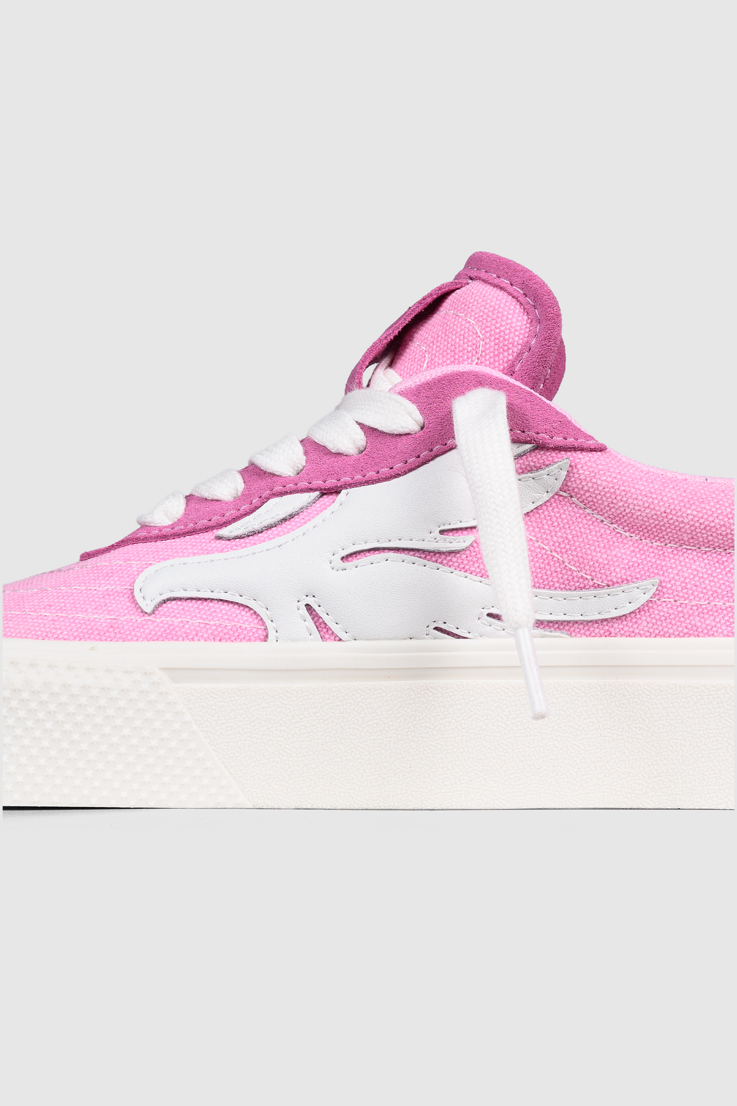 A close-up of the PESOCLO Peso Skate, a pink sneaker crafted from a canvas-suede mix, featuring white laces, a signature wavy white design on the side, and a thick white rubber sole.